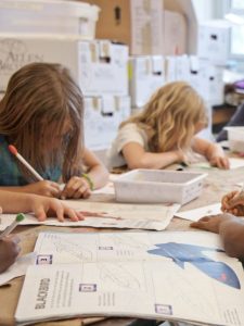cropped-back-to-school-children-sitting-at-their-desks-in-a-classroom.jpg