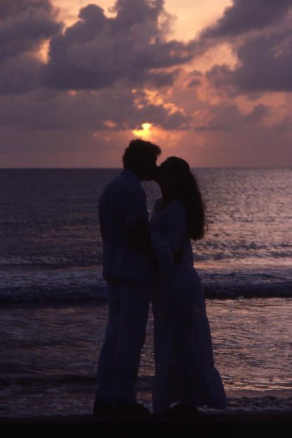 kissing on beach at sunset